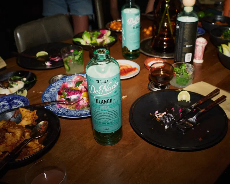 A bottle of De Nada Blanco on the dinner table after the meal
