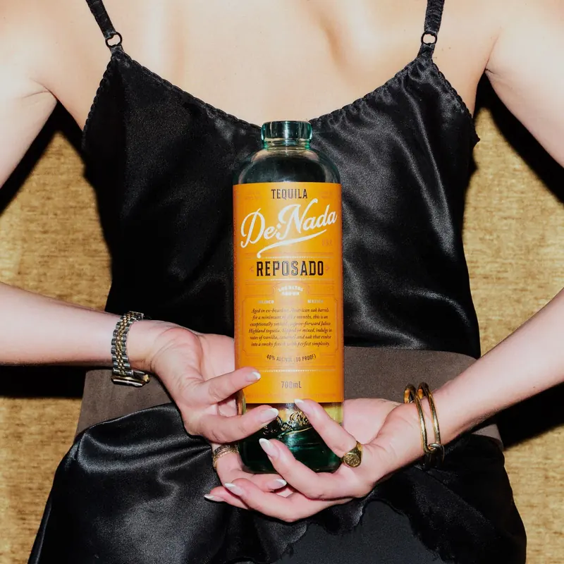 A bottle of De Nada Reposado held behind a guest&rsquo;s back